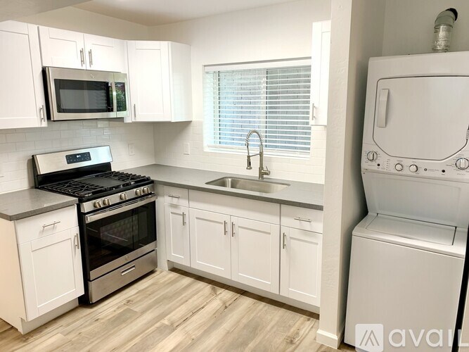 A kitchen with white cabinets and a black stove top oven.