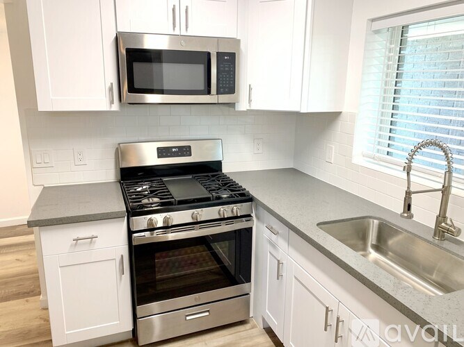 A kitchen with white cabinets and a stainless steel stove.