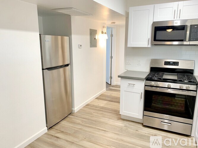 A kitchen with a stainless steel refrigerator, microwave, oven, and cabinets.
