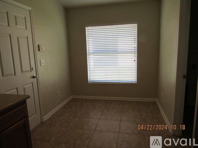 A room with a door, window, and tiled floor.
