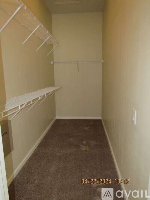 Empty room with white shelves and a carpeted floor.