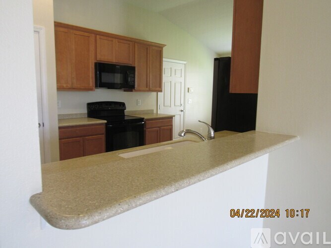 A kitchen with wooden cabinets and black appliances.