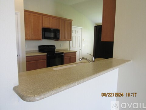 A kitchen with wooden cabinets and black appliances.