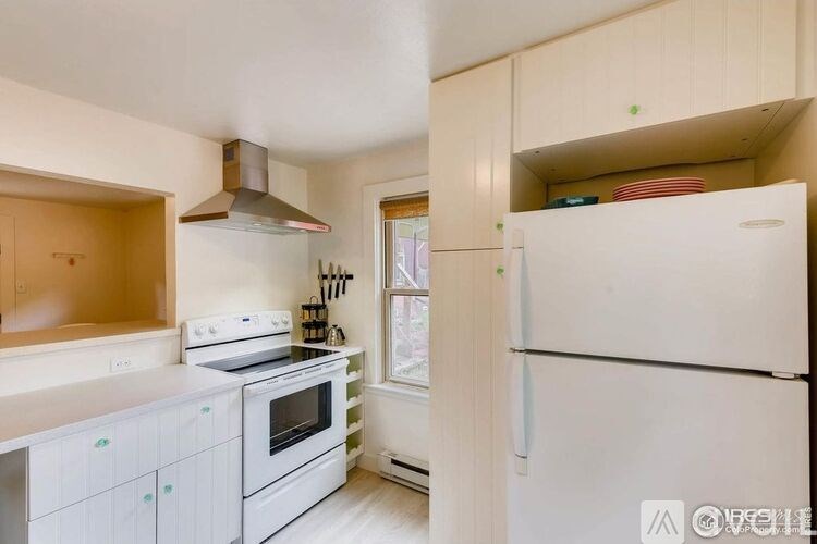 A kitchen with white appliances and cabinets.