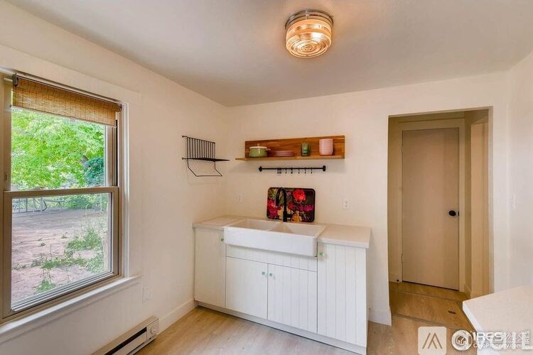 A white bathroom with a window and a sink.
