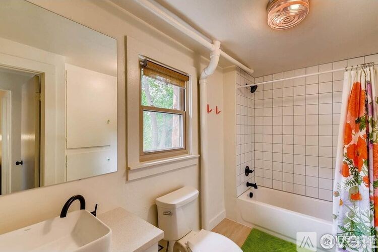 A bathroom with a white sink, toilet, and tub.