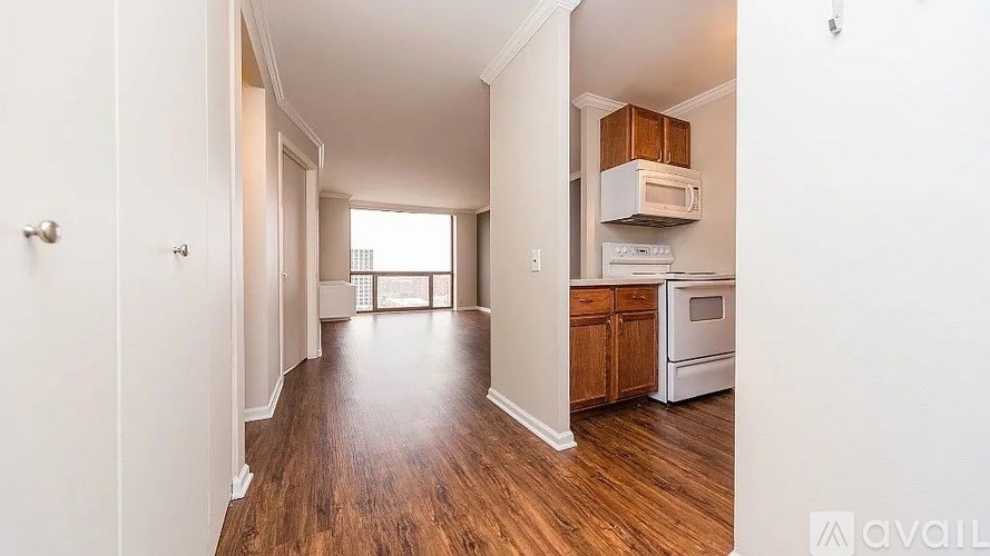 A kitchen with white appliances and wooden floors.