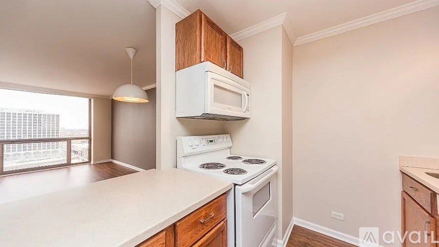 A kitchen with white appliances and wooden cabinets.