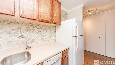 A kitchen with wooden cabinets and a white fridge.