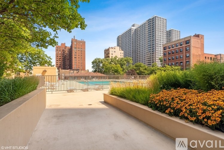 A view of a cityscape with buildings, trees, and a pool.