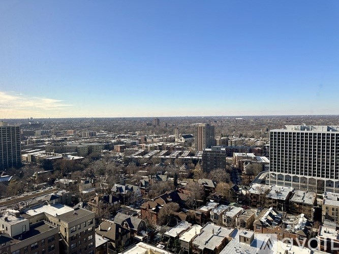A cityscape with a mix of residential and commercial buildings under a clear sky.