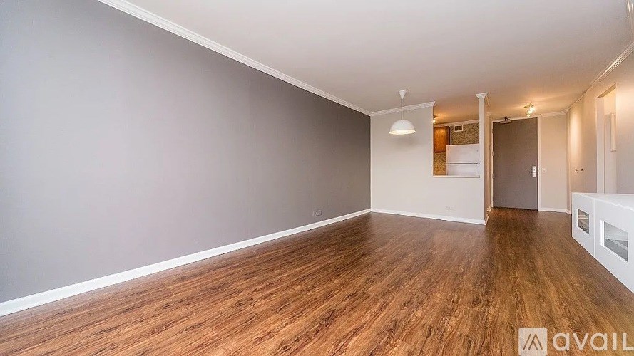 A room with wooden flooring and white walls.