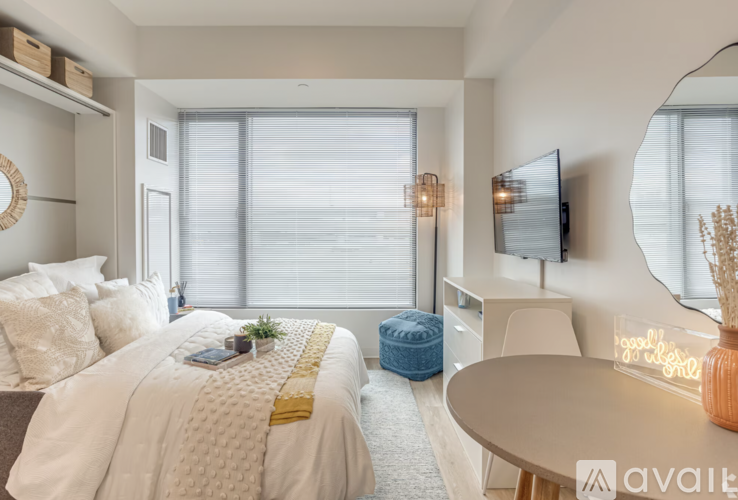 A bedroom with a bed, a desk, and a chair.