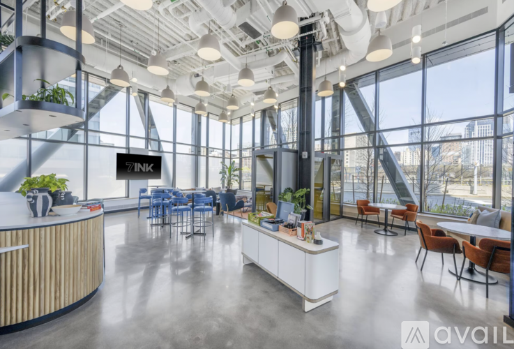 A modern office space with a reception desk and multiple seating areas.