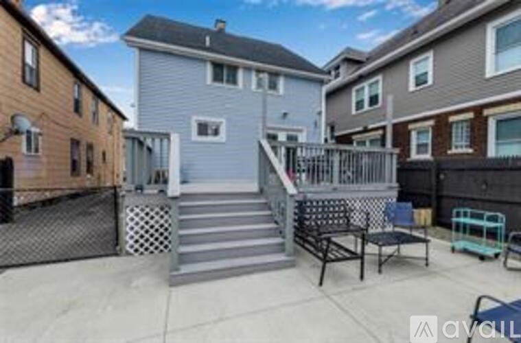 A patio with a metal railing and steps leading to a house.