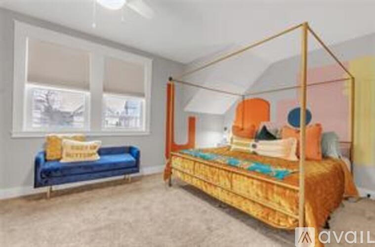 A bedroom with a canopy bed and a blue couch.