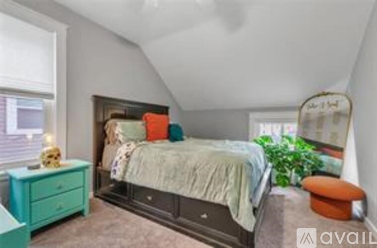 A bedroom with a bed, nightstand, and window.