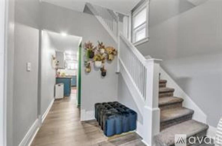 A hallway with a staircase and a wall-mounted decorative item.