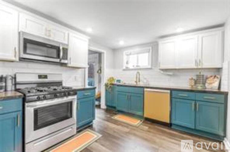 A kitchen with a stove, microwave, and cabinets.