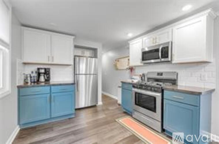 A kitchen with blue cabinets and stainless steel appliances.