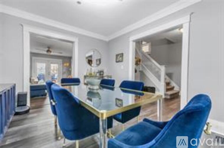 A dining room with a glass table and blue chairs.