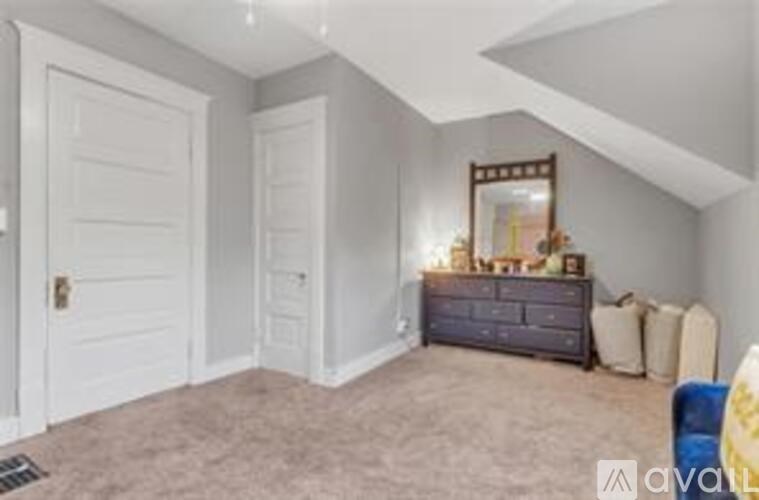 A bedroom with a dresser and mirror.
