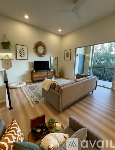 A living room with a couch, a television, and a ceiling fan.
