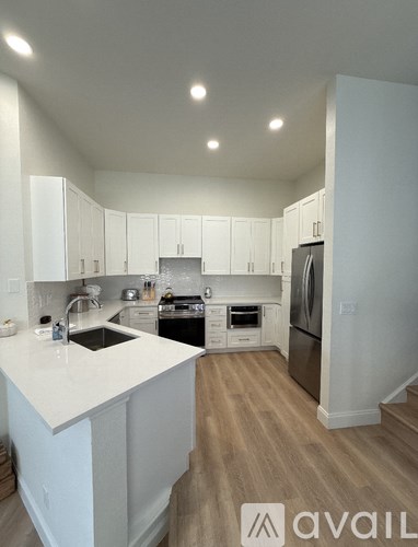 A kitchen with white cabinets and a white countertop.