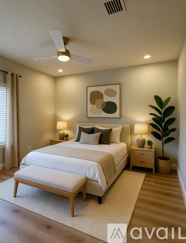 A bedroom with a large bed and a ceiling fan.