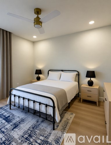 A bedroom with a large bed and a ceiling fan.