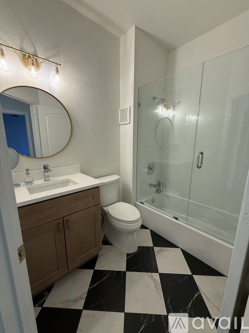 A bathroom with a black and white checkered floor.