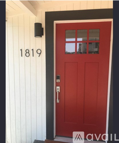 A red door with the number 1819 on the wall above it.