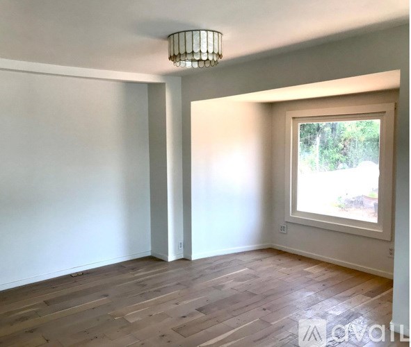 A room with a window and a chandelier.