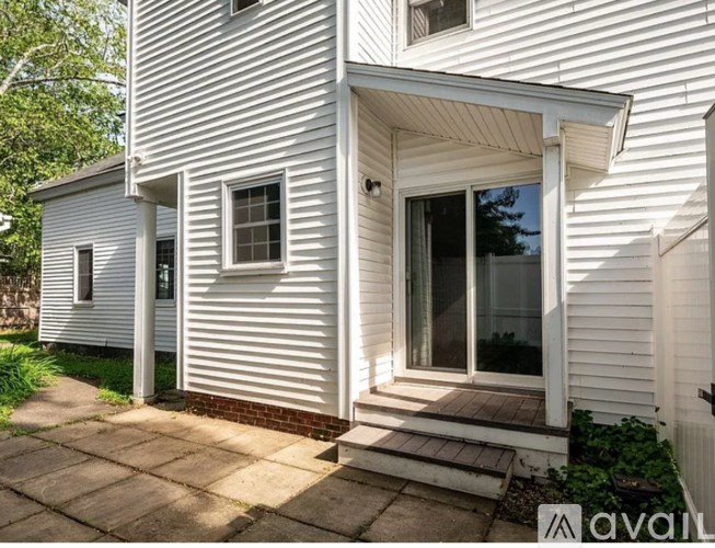 A white house with a porch and a window.