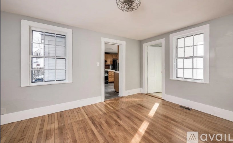 A room with wooden floors and two windows.