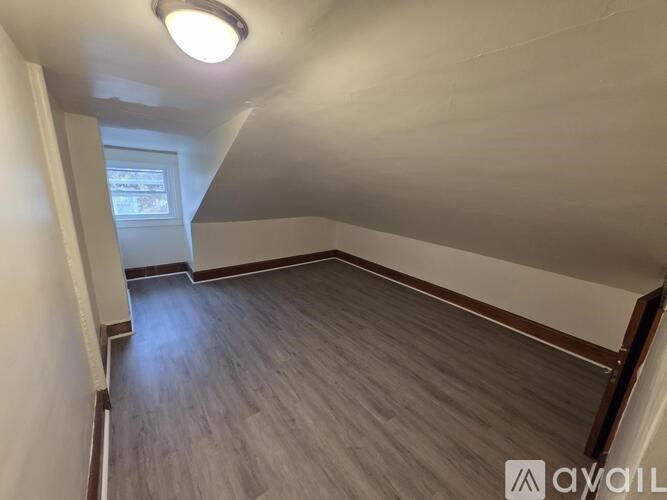 A room with wooden flooring and a window.