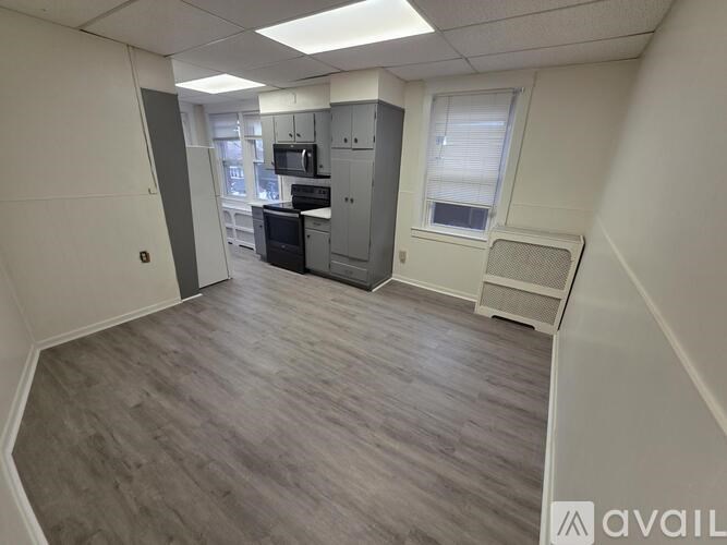 A spacious office room with a kitchenette and a window.