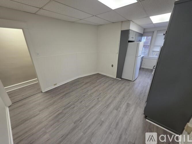 A spacious office room with a grey floor and white walls.