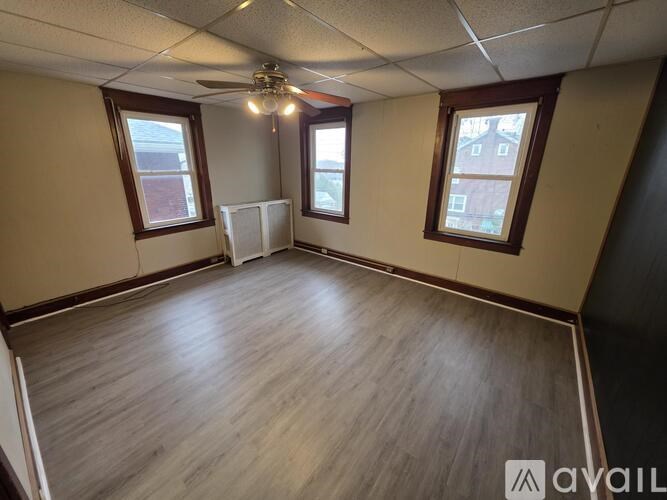 A room with wooden flooring and a ceiling fan.