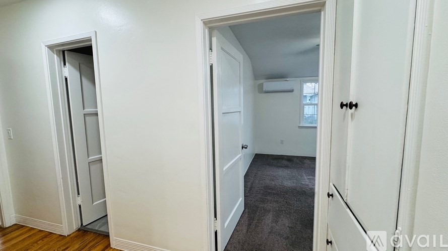 A room with a carpeted floor and a doorway leading to another room.