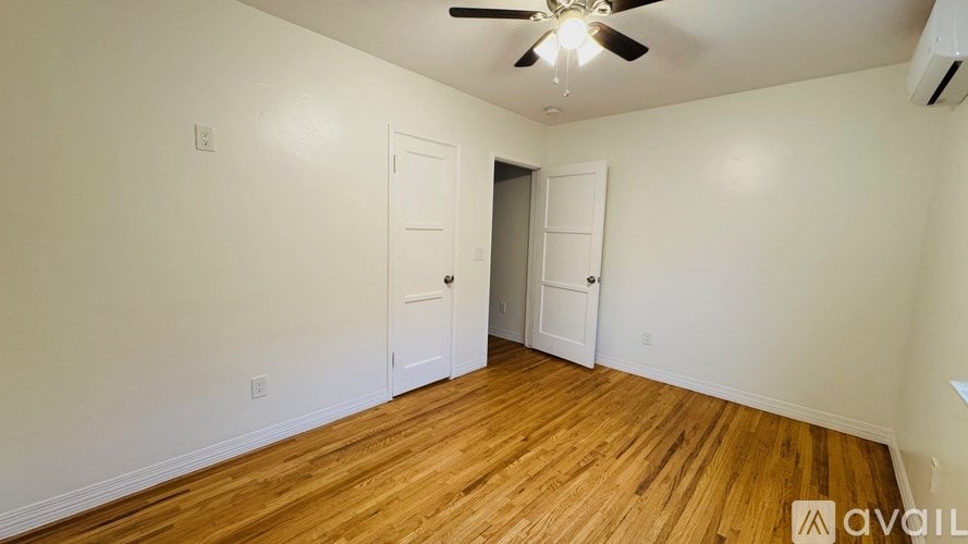 A room with wooden floors and a ceiling fan.