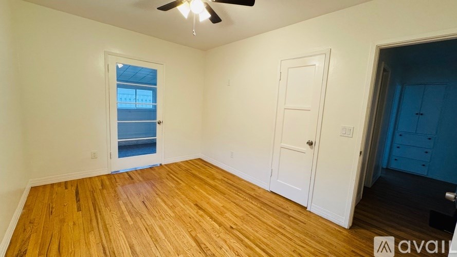 A room with wooden floors and a ceiling fan.