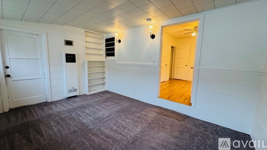 A room with a carpeted floor and white walls.