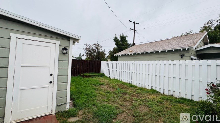 A white fence runs along the side of a house.