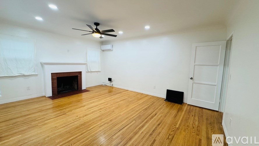 A room with a fireplace and a ceiling fan.