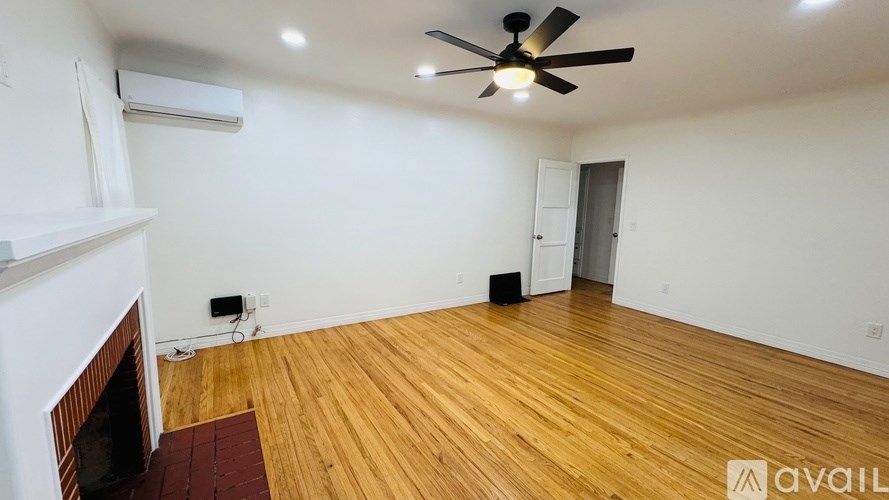 A room with a fireplace and a ceiling fan.