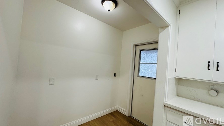A small room with a window and a cabinet.