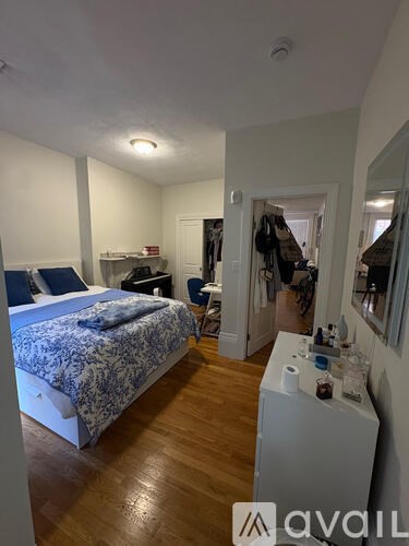A bedroom with a bed, a chair, and a dressing area.