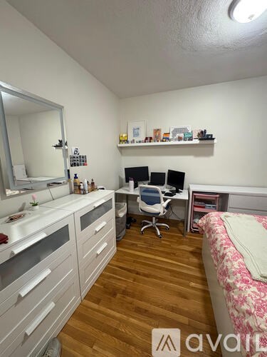 A bedroom with a bed, desk, and chair.