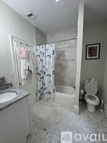 A bathroom with a toilet, sink, and shower.
